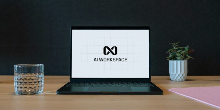 Masada duran laptop ekranında AI WORKSPACE yazısı ve yandaki bardak