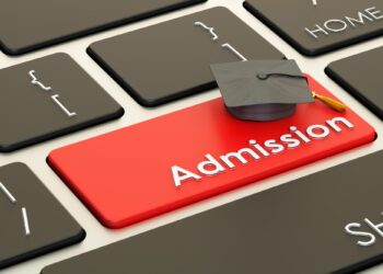 Üzerinde mezuniyet kepi bulunan kırmızı 'Admission' tuşlu siyah bilgisayar klavyesi.