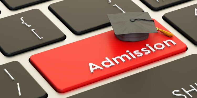 Üzerinde mezuniyet kepi bulunan kırmızı 'Admission' tuşlu siyah bilgisayar klavyesi.