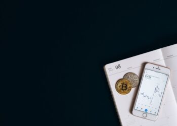 Bitcoin ve token görseli, akıllı telefonda borsa grafiği ve takvim.