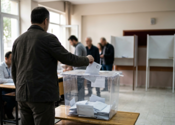 Sınıfta oy sandığına oy pusulası atan seçmenlerin bulunduğu temsili seçim ortamı.