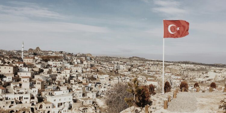Türkiye'de tarihi bir kasaba manzarası ve dalgalanan Türk bayrağı.