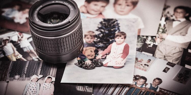 Eski siyah beyaz çocukluk fotoğraflarının üzerine yerleştirilmiş kamera lensi.