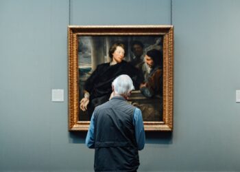 Sanat müzesinde tablonun önünde durarak eseri inceleyen yaşlı adam.