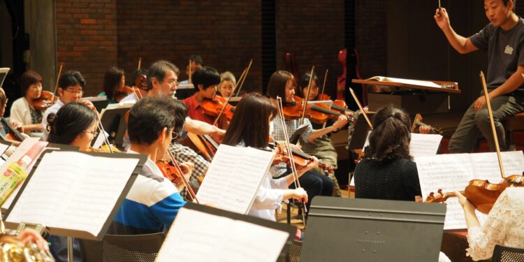 Şefin yönetiminde keman çalan müzisyenlerin yer aldığı orkestra provası