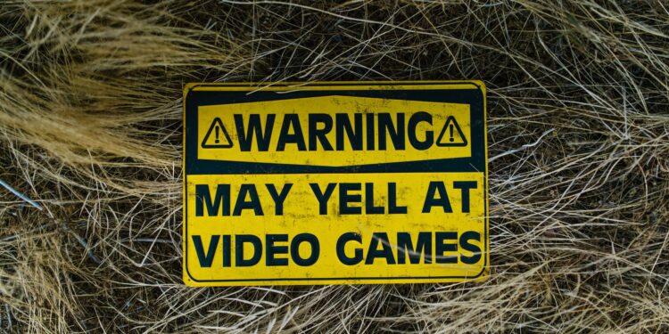 Kuru otlar arasında 'Warning' yazılı sarı renkli uyarı levhası.