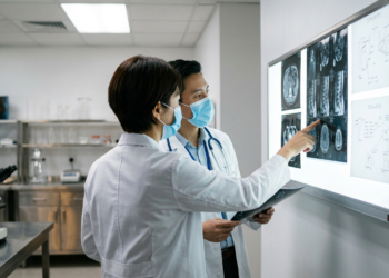Laboratuvarda tıbbi görüntüleri inceleyen iki doktor.