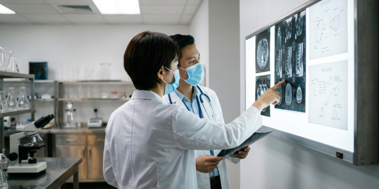 Laboratuvarda tıbbi görüntüleri inceleyen iki doktor.