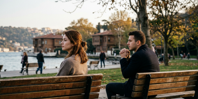 Boğaz manzaralı parkta iki ayrı bankta oturan düşünceli genç kadın ve erkek.