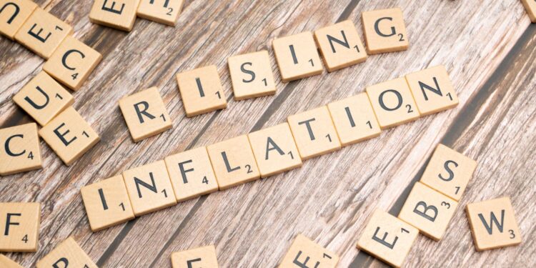 Ahşap harf karolarından oluşturulmuş 'RISING INFLATION' yazısı ve dağınık harfler.