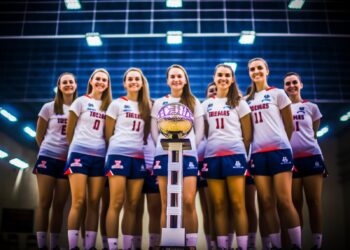 Kupa kazanan ve arkalarında mavi ışıklar bulunan voleybolcu kadınlar