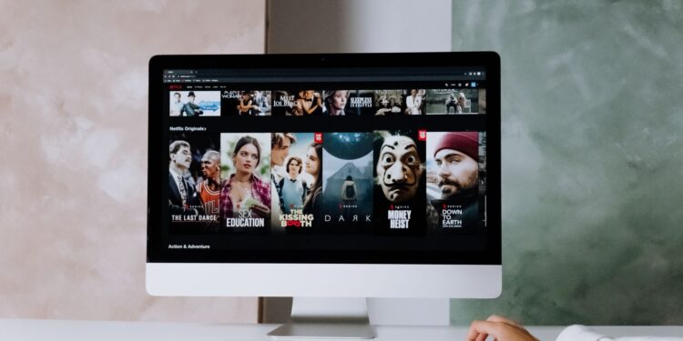 Bilgisayar ekranında Netflix ana sayfası ve film afişleri açık durumda.