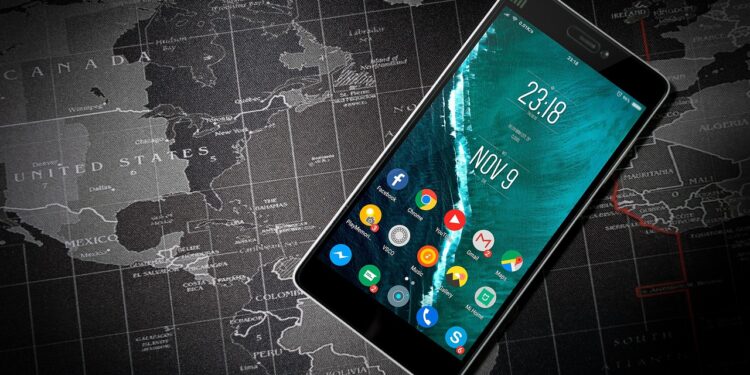 Siyah renkli akıllı telefonun ekranında saat ve çeşitli uygulama simgeleri görünüyor.