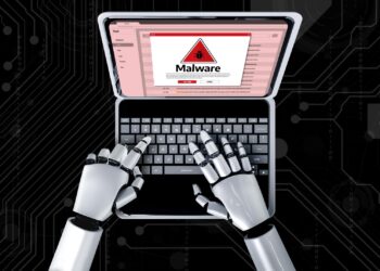 Robot elleri dizüstü bilgisayarda malware uyarısı ekranına yazı yazıyor.