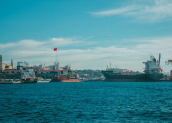 İstanbul limanında demirli büyük kargo gemileri ve arka planda tarihi binalar.